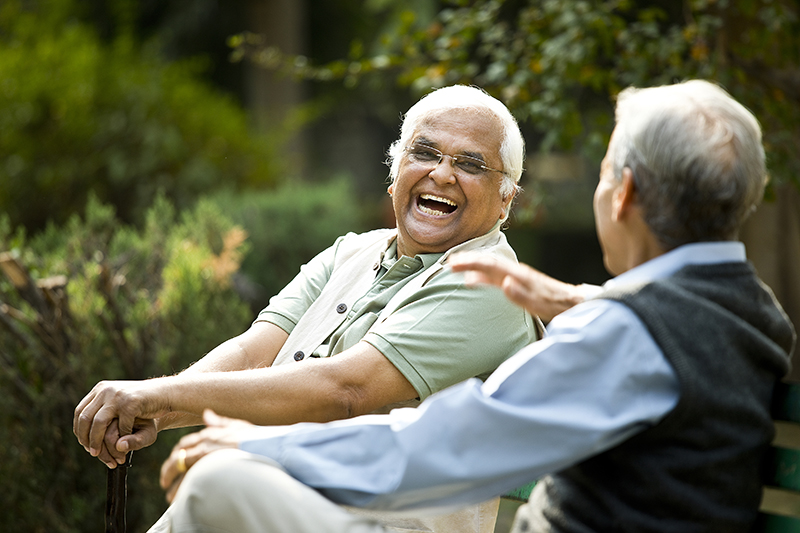 Two senior aged gentlemen sitting on a bench at Charter Senior Living of Rockford